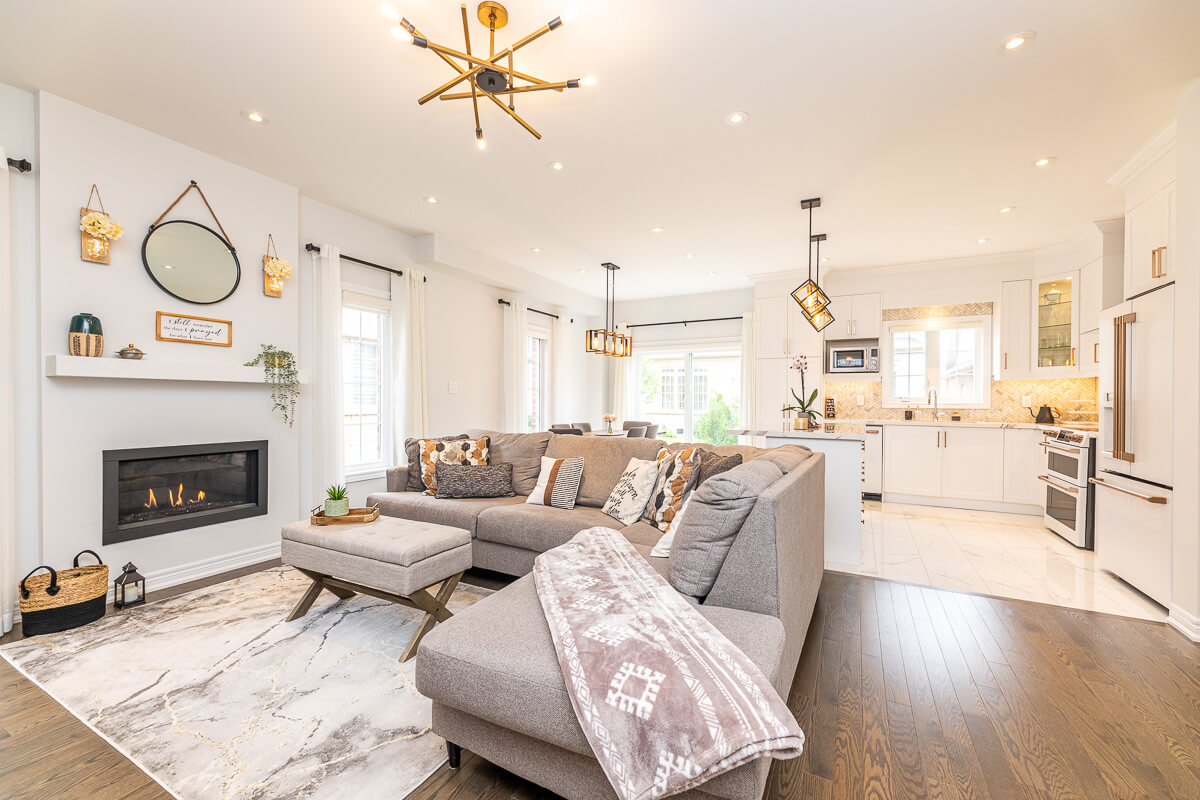 Toronto real estate photography bright open concept living room with modern kitchen and fireplace