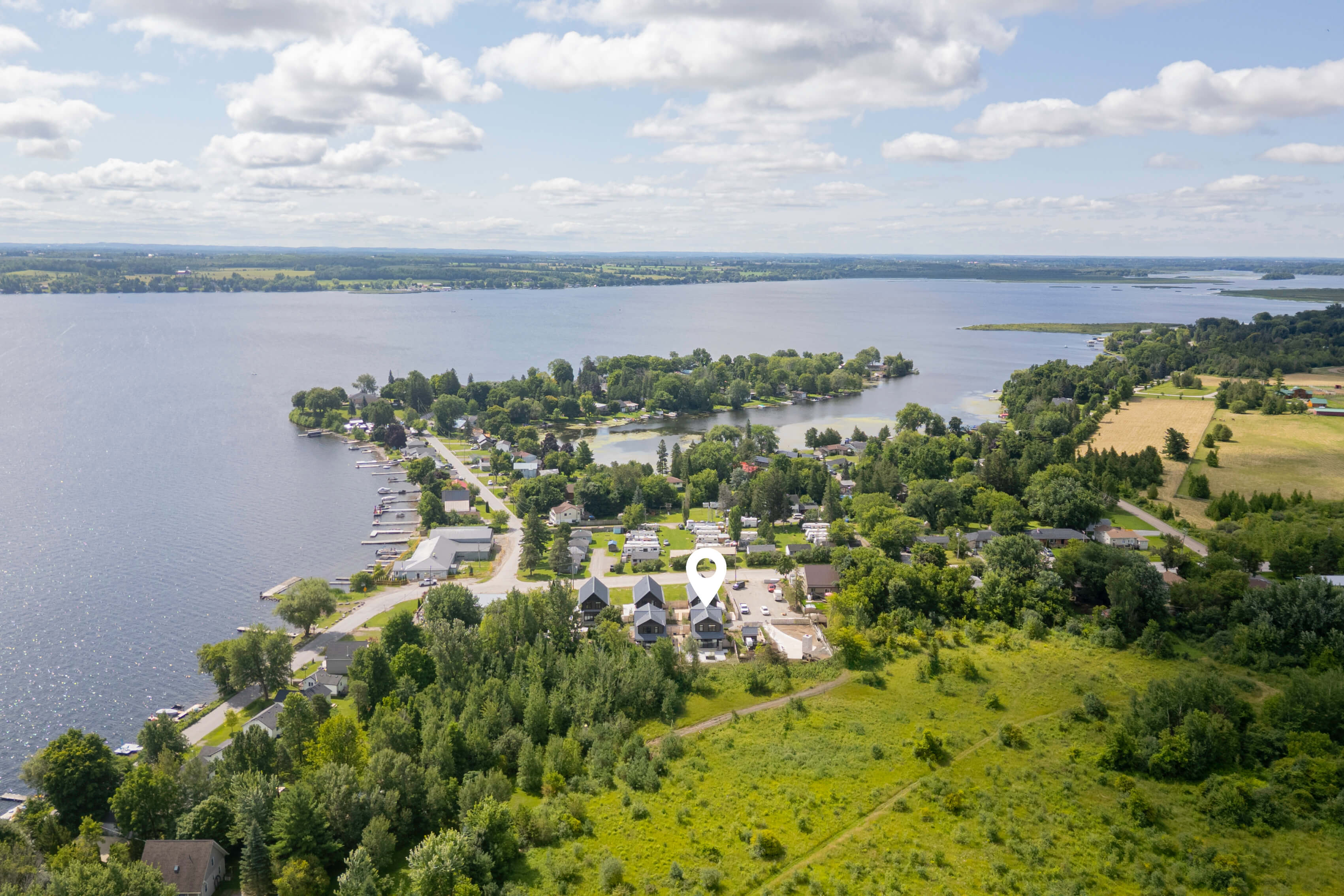 Aerial view of beachfront Airbnb property on Lake Erie, Ontario — private sandy beach with staircase access, autumn foliage and turquoise water
