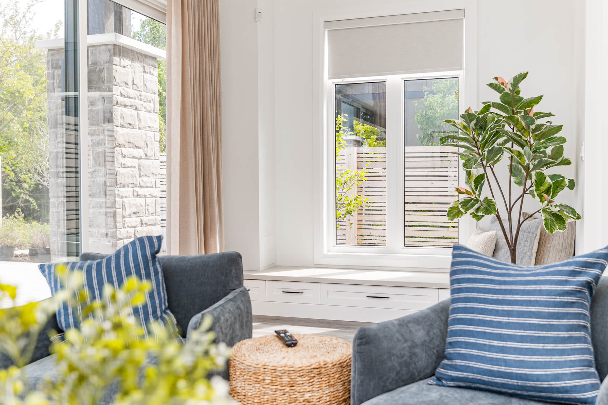 Bright and airy Airbnb bedroom in Ontario — queen bed with neutral linens, wood nightstands, arched mirror and large windows with green garden views