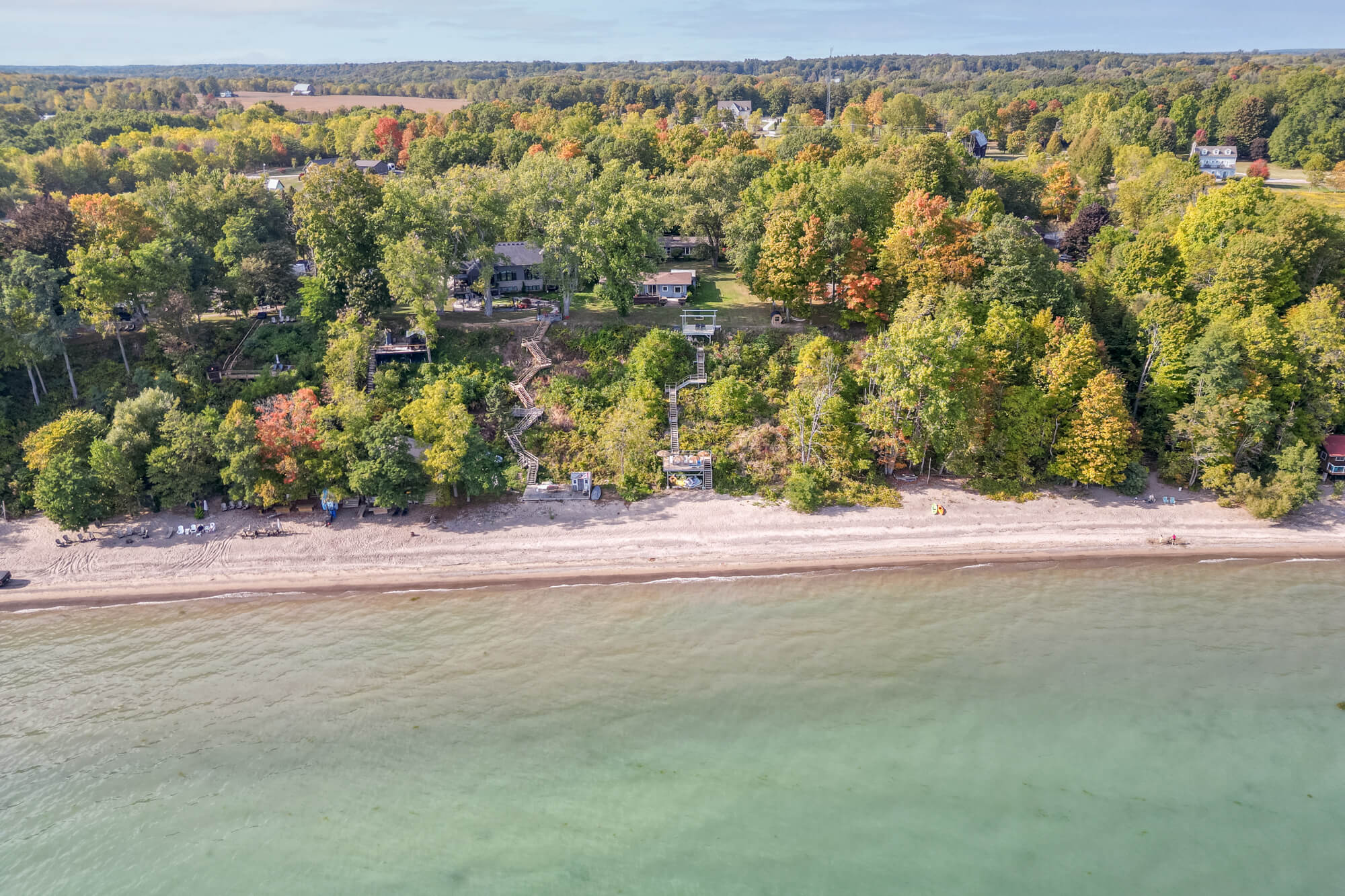 Aerial drone view of lakefront Sturgeon Lake Airbnb property in Ontario — waterfront village setting with marina, surrounded by mature trees and open lake views