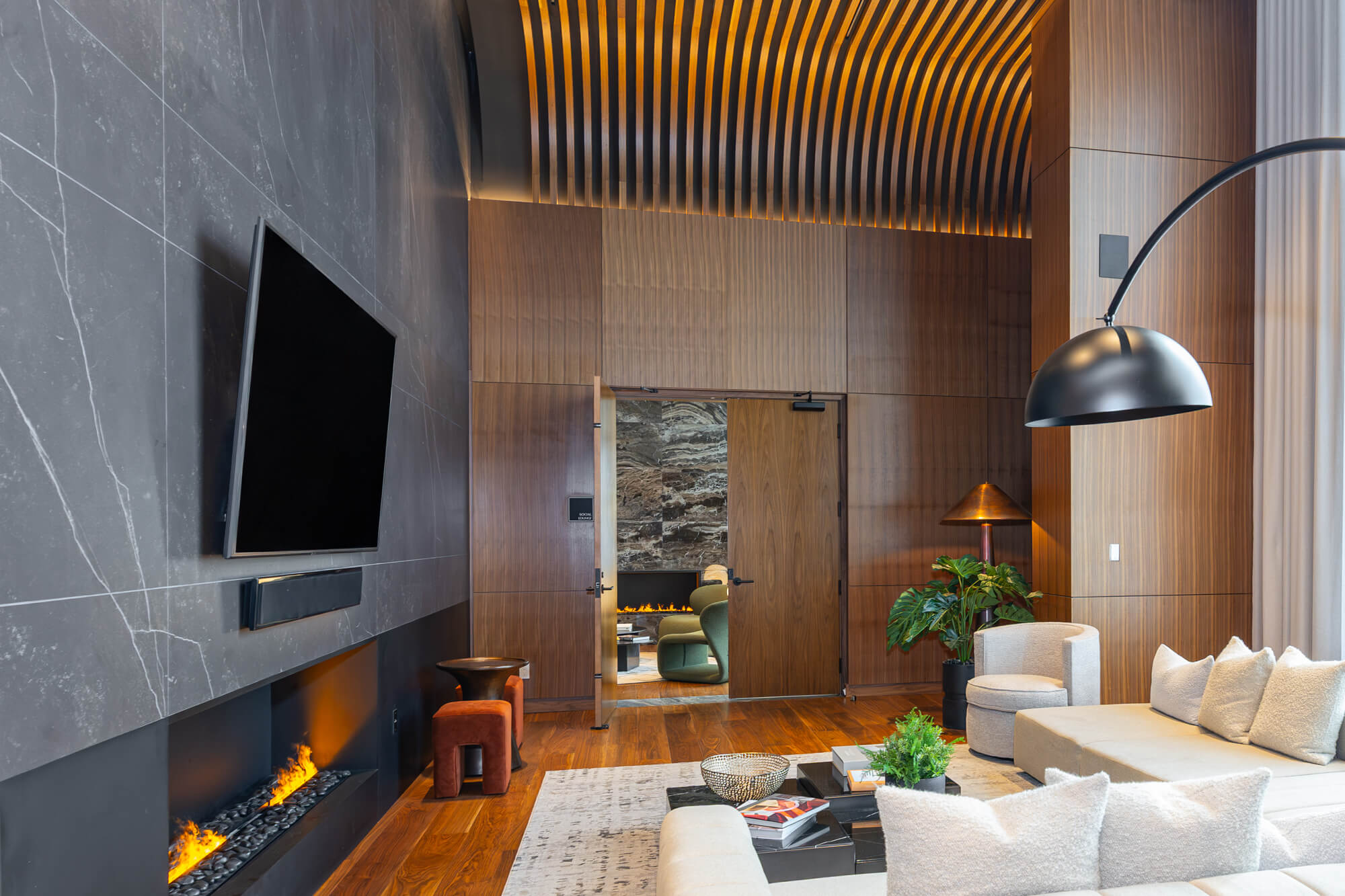 Commercial interior photography in Toronto showing a luxury amenity lounge with fireplace, staircase and modern design